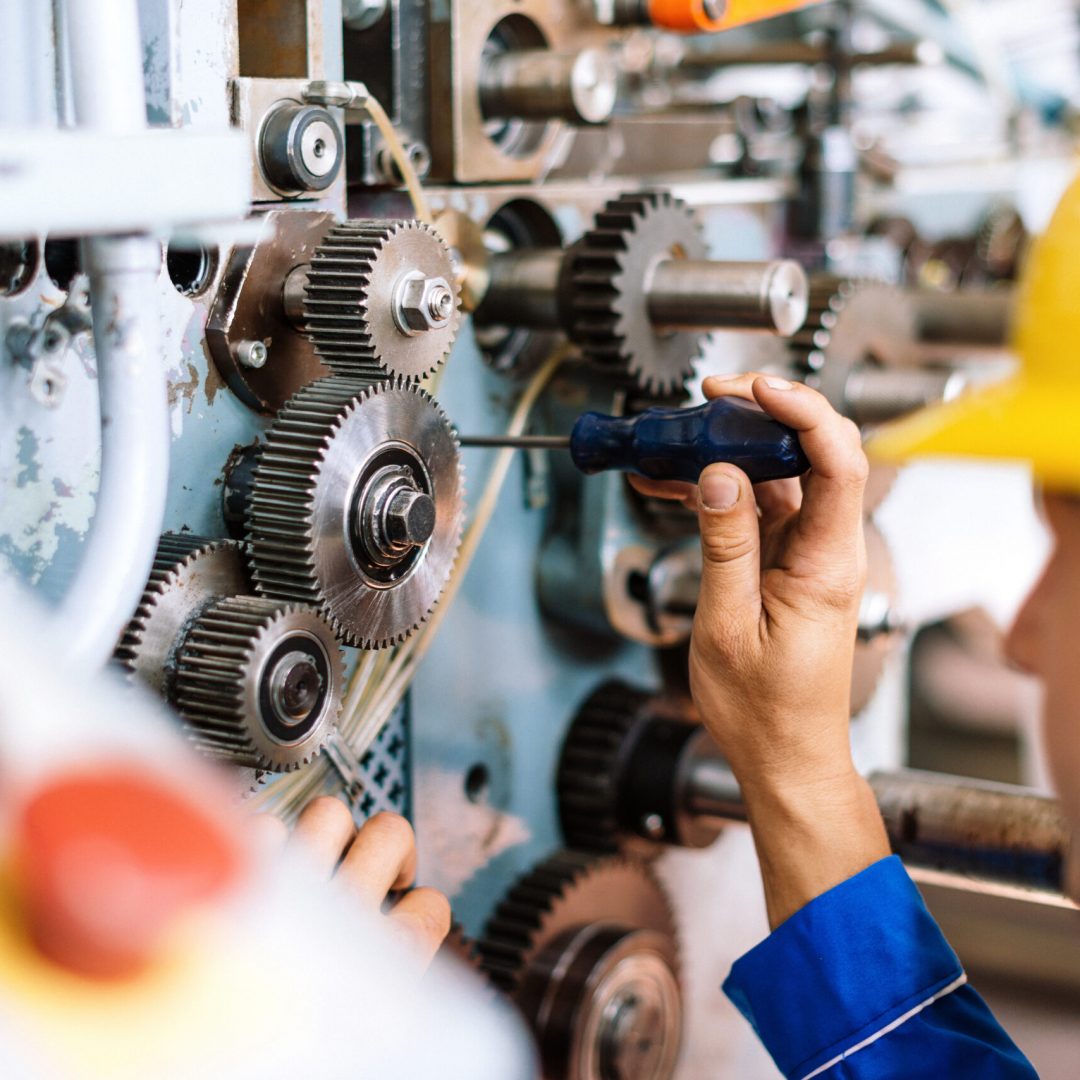 Machinist precisely setting up cog wheels Blue collar worker or engineer working in industrial production plant, dealing with metal processing, hydraulic machinery, production lines and other processing industry machines. Image taken in Serbia, Europe.