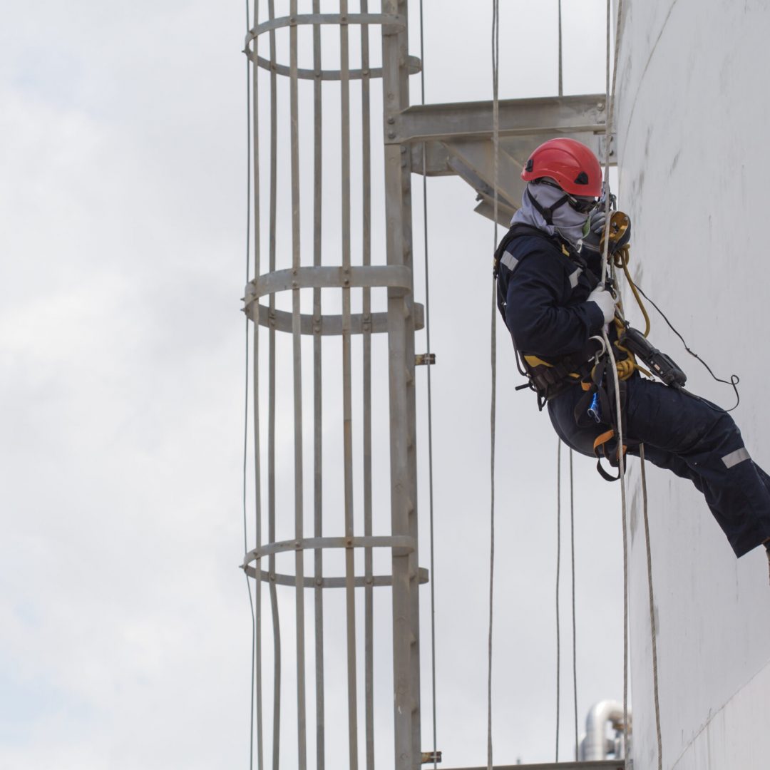 Male worker rope access inspection of thickness storage tank in Male worker rope access inspection of thickness storage tank industry close to stairway